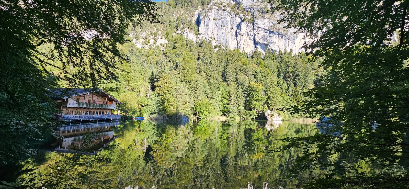 Berglsteiner See im Sommer – Bergwald und Felswand spiegeln sich im glatten Wasser