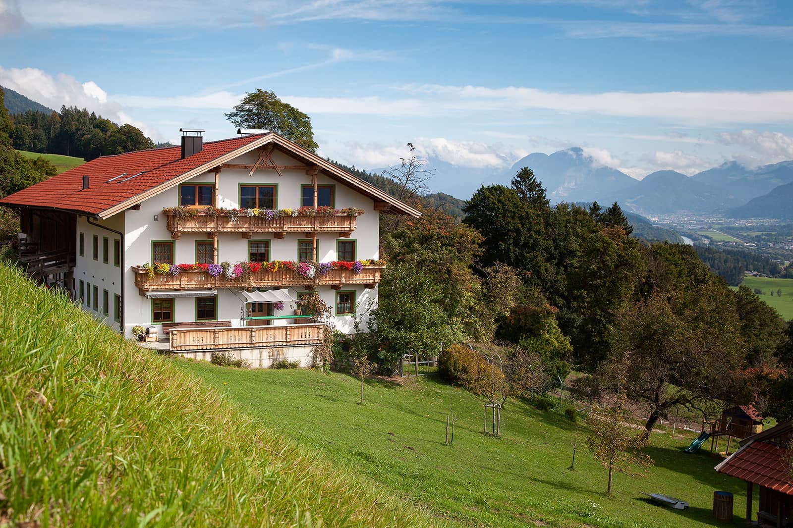 Wohnhaus mit blumengeschmückten Balkonen am sonnigen Hang